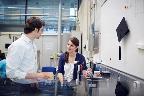 Source: THI Two doctoral students discuss technical equipment in the laboratory