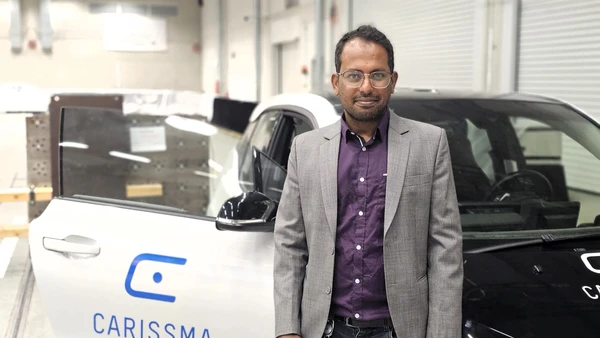 Portrait mit Mann im Vordergrund, hinter Ihm ein Auto mit "CARISSMA"-Label auf der offenen Beifahrertüre