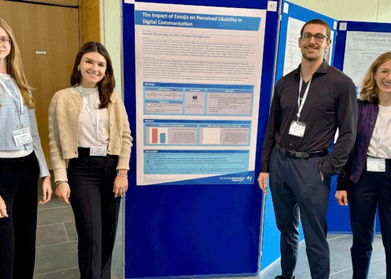 Four people in front of a pinboard. 