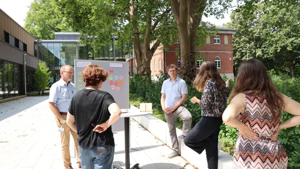Researchers from various disciplines discussed solutions (Photo: THI). Fünf Personen im Außenbereich des Campus in Neuburg, die vor einer Pinnwand mit unterschiedlichen Tags stehen und dieskutieren