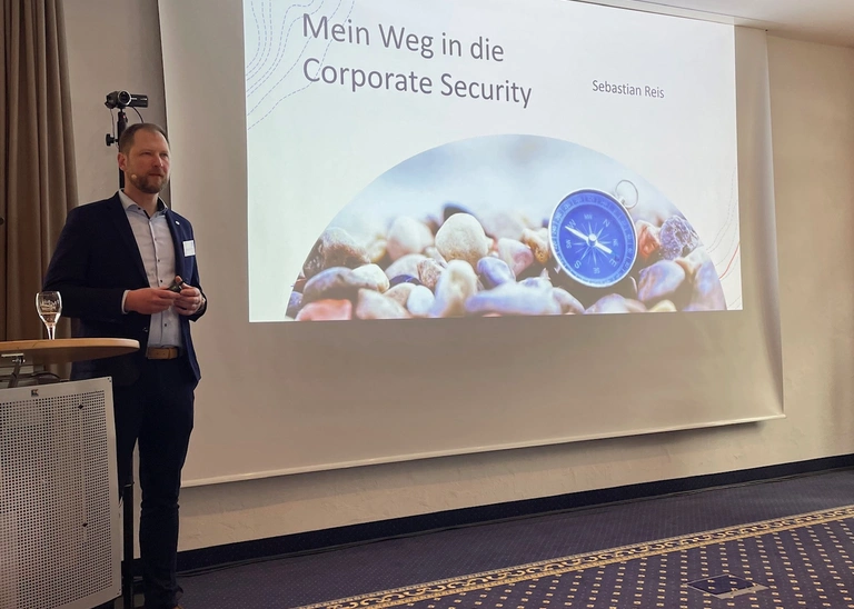 Mann beim Vortrag vor Leinwand